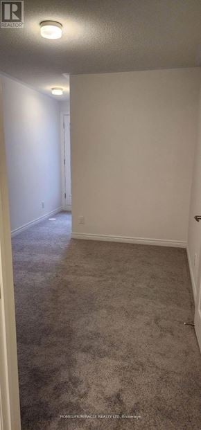 Oshawa (Kedron) townhouse for rent - A hallway with a carpeted floor and white walls.