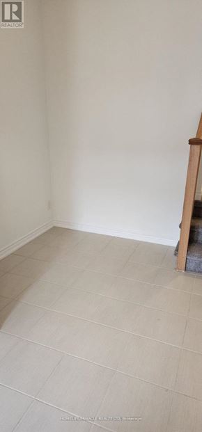 Oshawa (Kedron) townhouse for rent - A room with white walls and a wooden staircase.