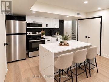 Niagara Falls (Brown) apartment for rent - A modern kitchen with a marble table and bar stools.