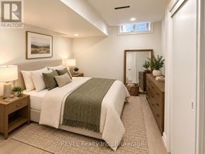 Niagara Falls (Brown) apartment for rent - A bedroom with a bed, nightstands, and a mirror.