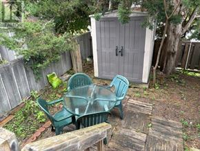 Ottawa townhouse for rent - A backyard with a wooden table and two green chairs.