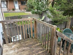Ottawa townhouse for rent - A wooden deck with a green chair and a white bag on it.
