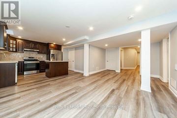 Vaughan (Vellore Village) apartment for rent - A spacious kitchen with dark wood cabinets and a light wood floor.