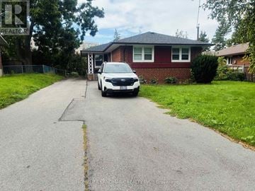 Toronto (Victoria Village) apartment for rent - A white car is parked in front of a red brick house.