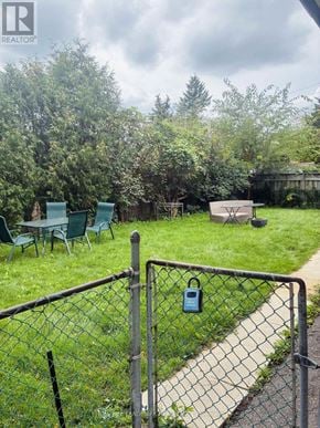 Toronto (Victoria Village) apartment for rent - A backyard with a fence and a table and chairs.