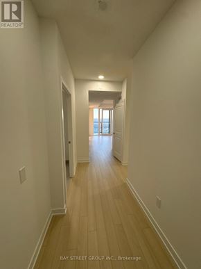 Brampton (Bram East) condo for rent - A long hallway with wooden floors and white walls.