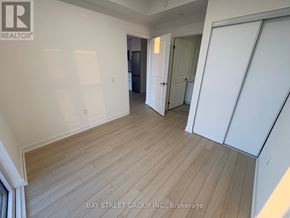 Brampton (Bram East) condo for rent - A room with wooden flooring and white walls, with a door on the right side.
