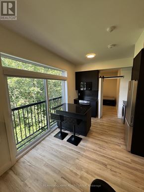 Ottawa multi-family for rent - A balcony with a table and chairs overlooks a green area.