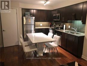 Toronto (Waterfront Communities) condo for rent - A kitchen with a table and chairs in front of a refrigerator.