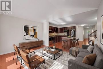 Waterloo townhouse for rent - A living room with a grey couch, a coffee table, and a painting on the wall.