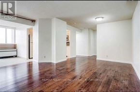 Toronto (Mount Olive-Silverstone-Jamestown) condo for rent - A large empty room with wood flooring and white walls.