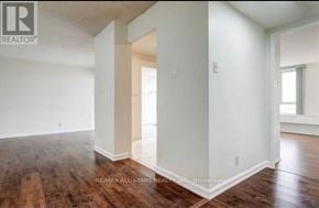 Toronto (Mount Olive-Silverstone-Jamestown) condo for rent - A room with wooden floors and white walls, with a doorway leading to another room.