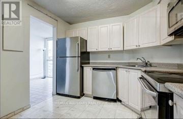 Toronto (Mount Olive-Silverstone-Jamestown) condo for rent - A kitchen with white cabinets and a stainless steel refrigerator.