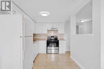 Kitchener townhouse for rent - A white kitchen with a refrigerator, stove and cabinets.