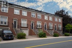 St. John's apartment for rent - A black truck is parked on the side of a street in front of a red brick building.