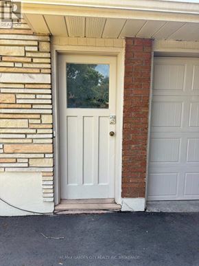St. Catharines (Carlton/Bunting) apartment for rent - A white door with a glass window is on a brick house.