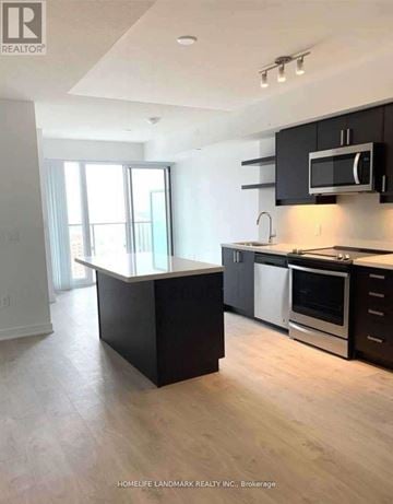 Toronto (Church-Yonge Corridor) condo for rent - A kitchen with black cabinets and a white countertop.