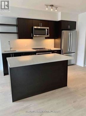 Toronto (Church-Yonge Corridor) condo for rent - A kitchen with a black counter top and a white fridge.
