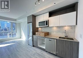 Toronto (Waterfront Communities) condo for rent - A modern kitchen with a large window and a view of the city.