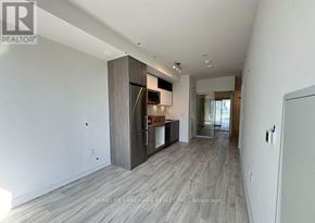 Toronto (Waterfront Communities) condo for rent - A spacious kitchen with a refrigerator, cabinets, and a countertop is visible.