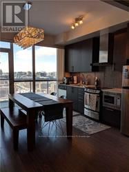Toronto (Waterfront Communities) condo for rent - A modern kitchen with dark wood floors and stainless steel appliances.