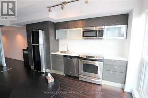 Toronto (Bay Street Corridor) condo for rent - A modern kitchen with stainless steel appliances and a black countertop.