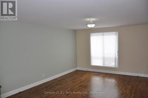 Orillia duplex for rent - A room with a window and wooden floors.
