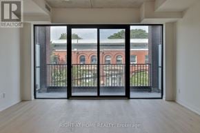 Toronto (South Riverdale) condo for rent - A room with a view of a brick building through a glass door.