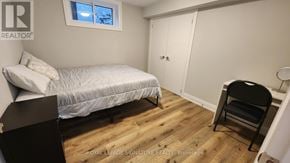 Mississauga (Lakeview) apartment for rent - A bedroom with a bed, chair, and wooden floors.
