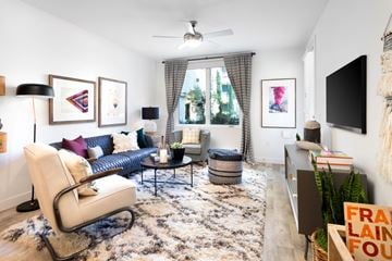 Pasadena apartment for rent - A living room with a white chair and a black and white rug.