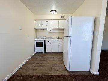 Louisville apartment for rent - A kitchen with white appliances and cabinets.