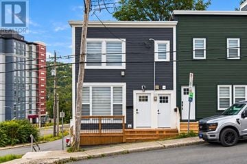 St. John's apartment for rent - A two-story house with a white door and windows is in front of a green house.