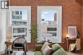 Hamilton apartment for rent - A living room with a green couch and a large window.