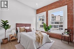 Hamilton apartment for rent - A bedroom with a large bed and a window overlooking a building.