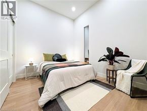 Hamilton apartment for rent - A bedroom with a large bed and a plant on the side table.
