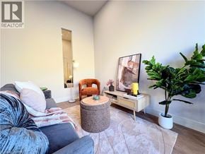 Hamilton apartment for rent - A living room with a grey couch, a wooden bench, a round table, and a potted plant.