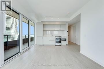 Mississauga (City Centre) condo for rent - A spacious, modern kitchen with white cabinets and a large island.
