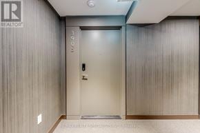 Mississauga (City Centre) condo for rent - A closed door with a handle and a lock is in a room with a carpeted floor.