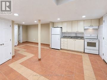 Toronto (Weston-Pellam Park) duplex for rent - A kitchen with white appliances and cabinets.