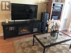 Mississauga (Hurontario) condo for rent - A living room with a black television and a fireplace.