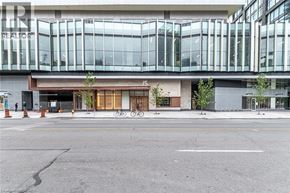 Toronto condo for rent - A large glass building with a bicycle parked in front.