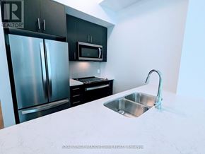 Hamilton (Waterdown) condo for rent - A kitchen with a stainless steel refrigerator, microwave, and sink.