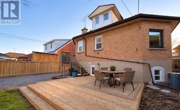 Oshawa (Mclaughlin) apartment for rent - A house with a brown brick exterior and a wooden deck in front.