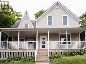 Huntsville fourplex for rent - A white house with a porch and a front door.