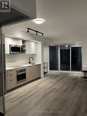 Toronto (Islington-City Centre West) condo for rent - A modern kitchen with wooden floors and a large island.
