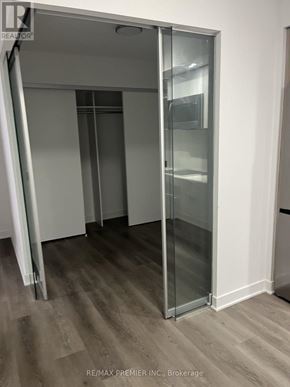 Toronto (Islington-City Centre West) condo for rent - A room with a glass door and wooden flooring.