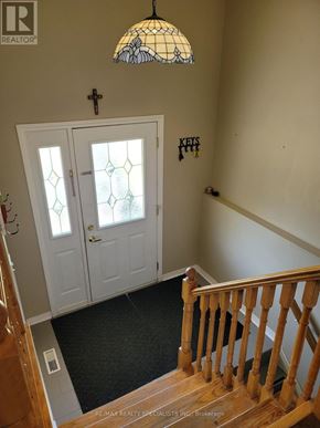 Mississauga (Meadowvale) apartment for rent - A staircase with a wooden banister and a glass door with a cross on it.