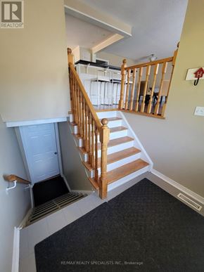Mississauga (Meadowvale) apartment for rent - A staircase with a wooden banister and a white door at the bottom.