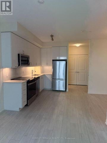 Toronto (Mimico) condo for rent - A kitchen with white cabinets and a stainless steel refrigerator.