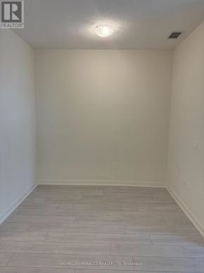 Toronto (Mimico) condo for rent - A room with a wooden floor and white walls.